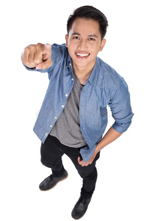 Young Asian Man Posing On The White Background Pointing At The Stock