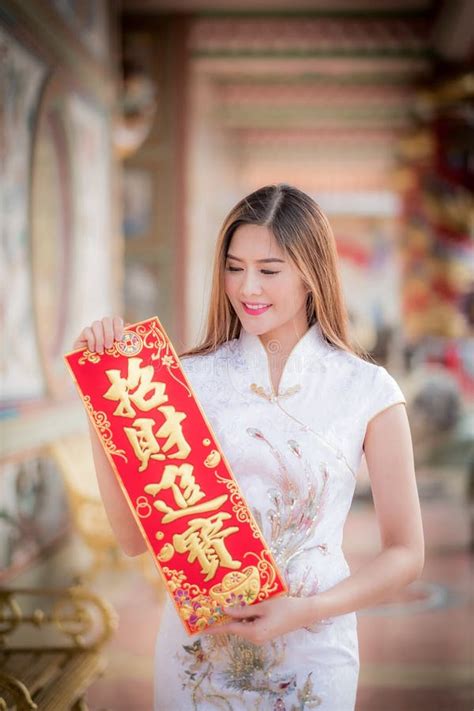 Азиатская женщина в китайце одевает держать двустишие сильный китаец