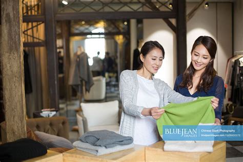 Chinese Clothing Store Owner Helping Customer With Choosing Chinese Clothing High Res Stock