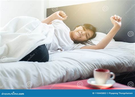 Asian Female Stretching And Yawn On Bed After Wake Up In The Morning