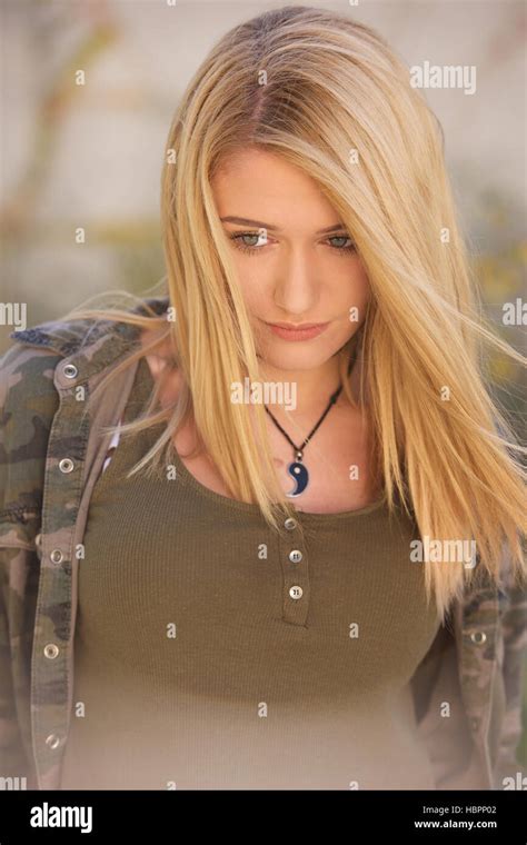 Blonde Teenage Girl In Jeans And Green Top Outdoors Stock Photo Alamy