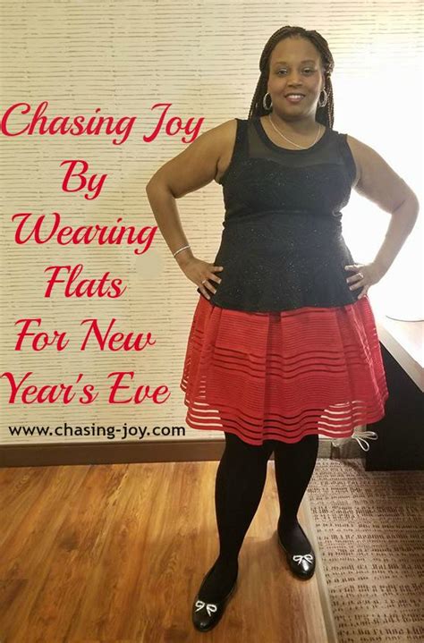 A Woman Standing In Front Of A Sign That Says Chasing Joy By Wearing