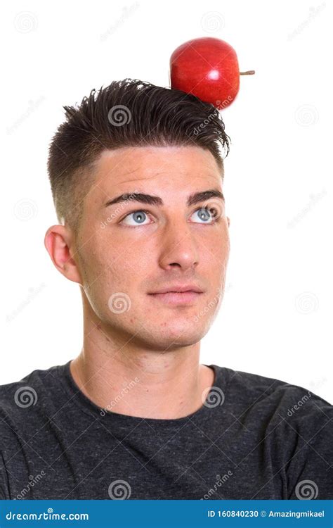 Studio Shot Of Young Handsome Man With Red Apple On His Head Stock
