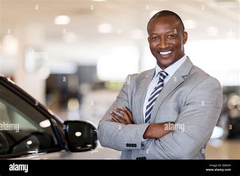 African American Car Dealership Principal Standing In Vehicle Showroom