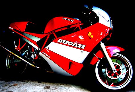 A Red And White Ducati Motorcycle Parked In The Dark