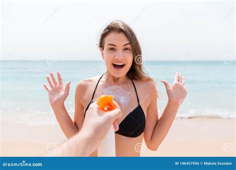 Man S Hand Is Suddenly Applying Suntan Lotion On Surprised Woman S