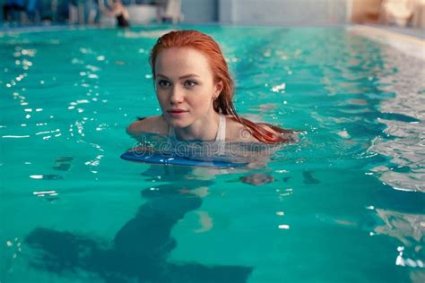 Beautiful Young Redhead Caucasian Girl Swims In The Indoor Swimming Pool Healthy Lifestyle