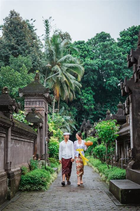 Balinese Couple Wearing Traditional Clothes Walking Together In Bali