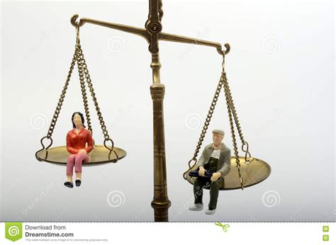 Man And Woman Sitting On Golden Weighing Scale Stock Photo