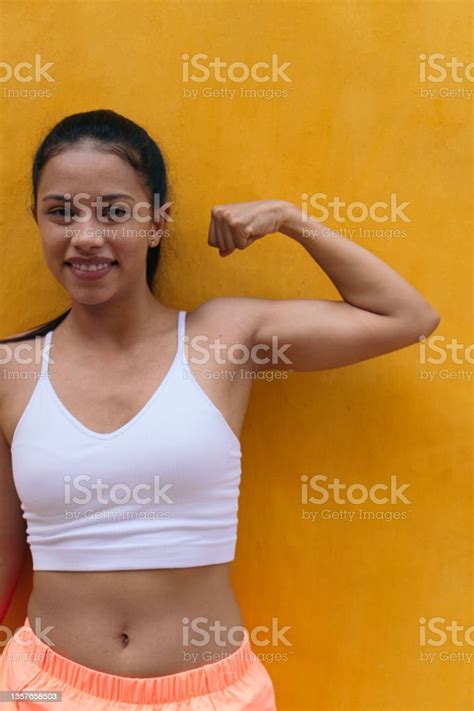 Woman Flexing Her Muscles In The Open Air Stock Photo Download Image