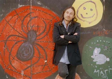 Poet And Native American Activist John Trudell Poses Against A Mural In