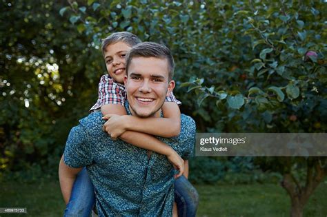 Big Brother Carrying Little Brother On The Back Stock Photo | Getty Images