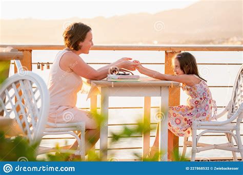 Madre Felice E Figlia Sedute All Aperto Al Tavolo Contro La Montagna E