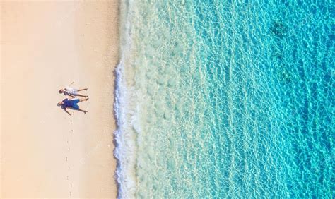 premium photo aerial view of a people couple on the beach on bali indonesia vacation and