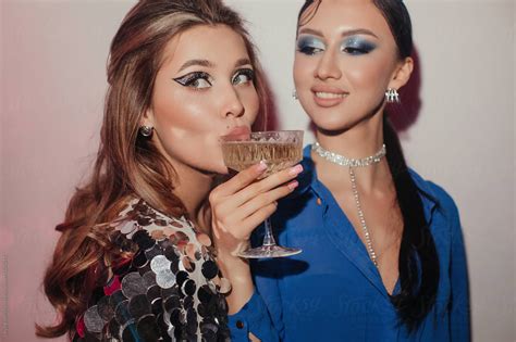 Fashionable Young Woman Giving Glass Of Sparkling Wine To Her Beautiful Girlfriend In 2022