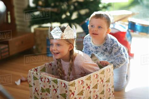Boy Pushing Sister In Cardboard Box At Christmas Stock Photo Dissolve