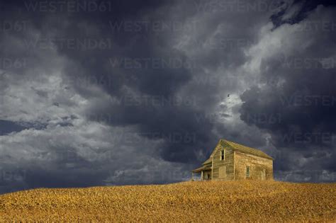 Storm Clouds Over Remote Wooden Farmhouse Stock Photo