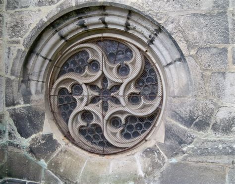 A Circular Window On The Side Of A Stone Building With An Intricate