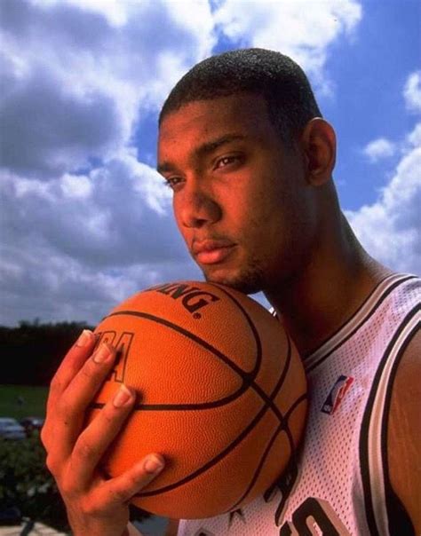 A Man Holding A Basketball In His Right Hand And Looking At The Camera With An Intense Look On