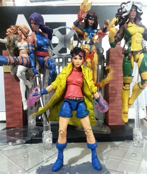 A Group Of Action Figures Are Posed In Front Of A Display Case On A Table