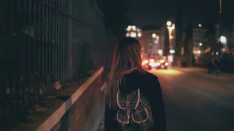 Back View Of Brunette Woman Walking Near The Road At The Traffic Time