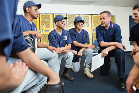 High School Baseball Coach Talking With Players In Locker Room Stock