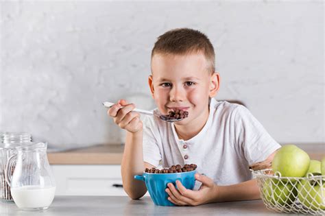 Anak Lakilaki Bahagia Makan Sarapan Kering Yang Sehat Dengan Susu Duduk