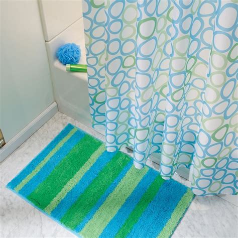 A Blue And Green Bathroom Rug Next To A Shower Curtain