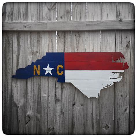 The original ordinance stated that the flag of this state shall be a blue field with a white v thereon, and a star, encircling which shall be the words the browne flag was not at all like that described in the original proposal but was, nevertheless, approved by the north carolina convention on june 22, 1861. North Carolina Shape Wood Cutout - State Flag | North ...