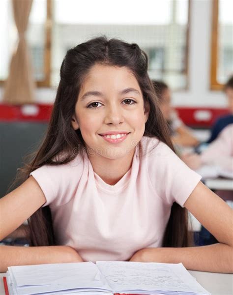 Schoolgirl Sitting At Desk In Classroom Stock Image Image Of Brunette