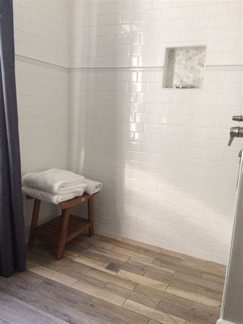 Gray glass tile with white grout is a winning color combination. Wood look ceramic tile floor, white subway tile with chair ...