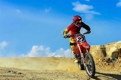 Person Driving Motocross Dirt Bike Under Blue Sky · Free Stock Photo