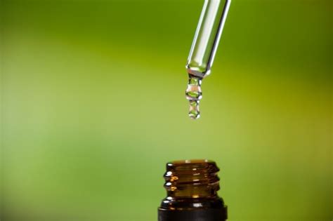 Free Photo Drop Of Oil Dripping From Pipette Into Bottle Of Essential Oil