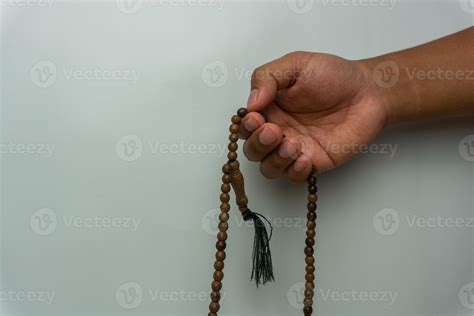 hand holding wooden tasbih beads isolated. islamic prayer beads. moslem