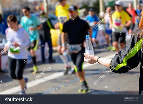 Marathon Running Race Runners On Road Volunteer Giving Water On
