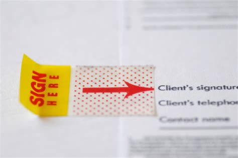Close Up Of Sign Here Sticker On A Legal Document Stock Photo