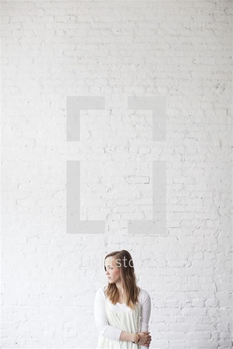 Stock Photo Shy Woman Standing In Front Of A Brick Wall And By