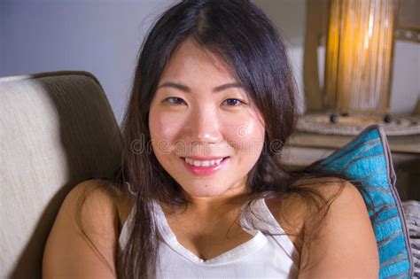 Lifestyle Close Up Portrait Of Young Beautiful And Happy Asian Chinese Woman Lying At Home Sofa