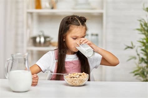 Cute Little Girl Eating Breakfast Cereal With The Milk Stock Photo