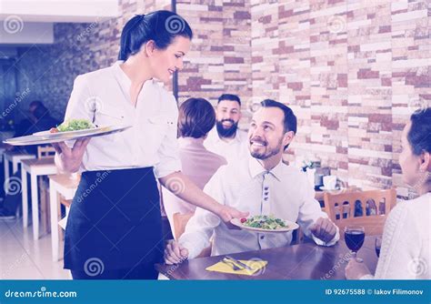Smiling Waitress Serving Meal For Restaurant Guests Stock Photo Image