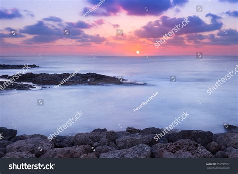 Purple And Pink Sunset Over Ocean Shore Stock Photo
