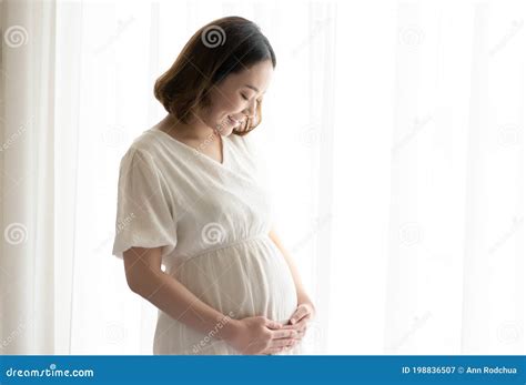 Asian Pregnant Woman Wearing White Dress And Standing Beside Window Stock Image Image Of