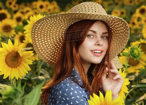 Smiling Caucasian Woman Wearing Hat In Field Of Sunflowers Stock