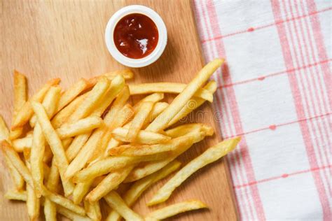 French Fries On White Paper With Ketchup Dining Table Stock Photo