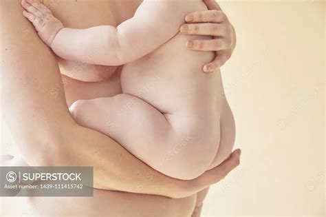 Naked Mother Carrying Naked Baby In Arms SuperStock