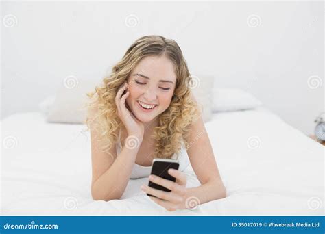 Pretty Smiling Blonde Lying On Bed Using Smartphone Stock Image Image