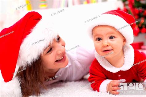 Our First Christmas Mother And Baby With Santa Hats Stock Photo