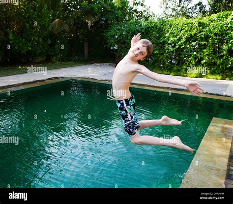 Boy Jumping Into Swimming Pool Stock Photo Alamy