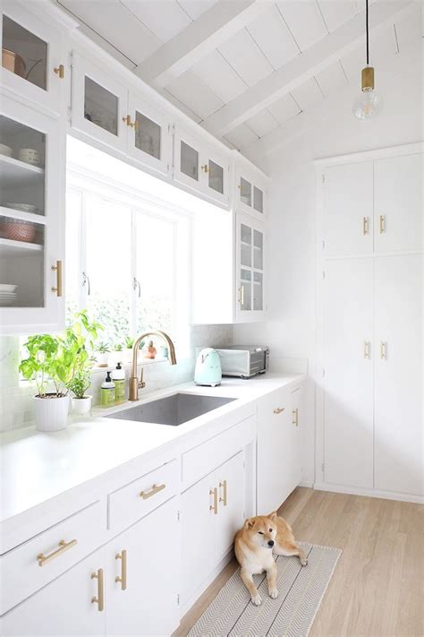 Neutral colored countertops and wooden open shelving keep this kitchen feeling natural. best 25 small white kitchens ideas on pinterest small ...