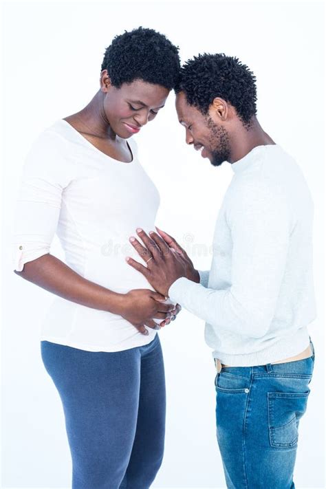 Cheerful Man Touching His Pregnant Wife Belly While Standing Stock